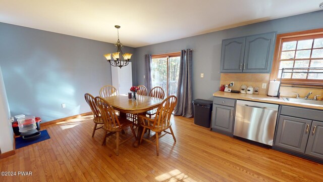 dining space featuring light hardwood / wood-style flooring, sink, and an inviting chandelier