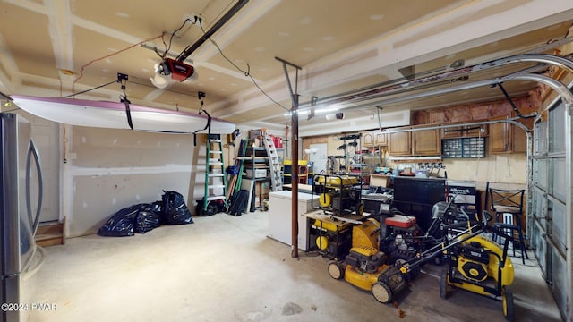 garage featuring a garage door opener, a workshop area, and stainless steel refrigerator