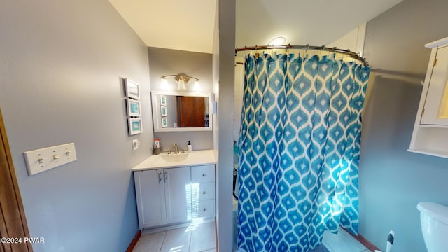 bathroom with curtained shower, tile patterned flooring, vanity, and toilet