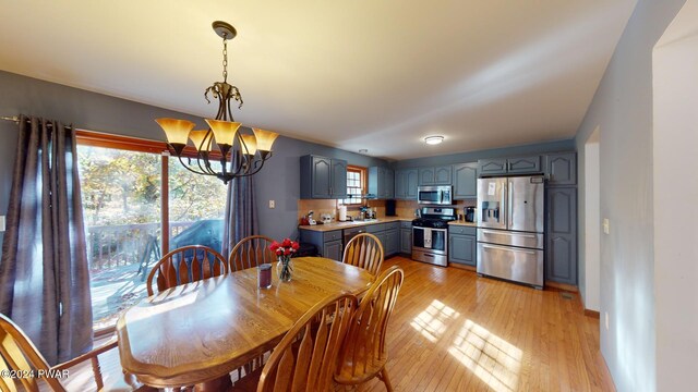 dining area with a notable chandelier and light hardwood / wood-style flooring