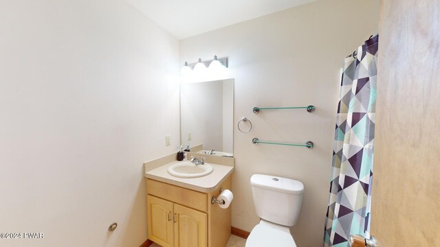 bathroom with a shower with shower curtain, vanity, and toilet