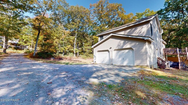 view of property exterior featuring a garage and a deck