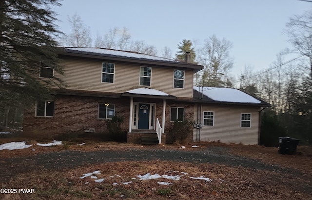 traditional-style home featuring entry steps and brick siding