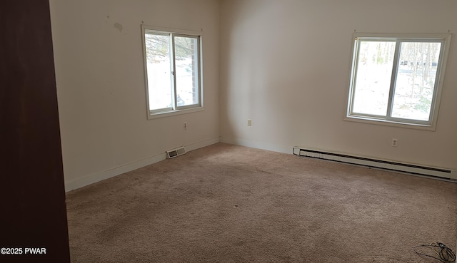 carpeted spare room with baseboard heating and visible vents