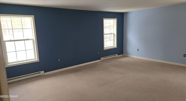 empty room featuring a baseboard heating unit, light carpet, and baseboards