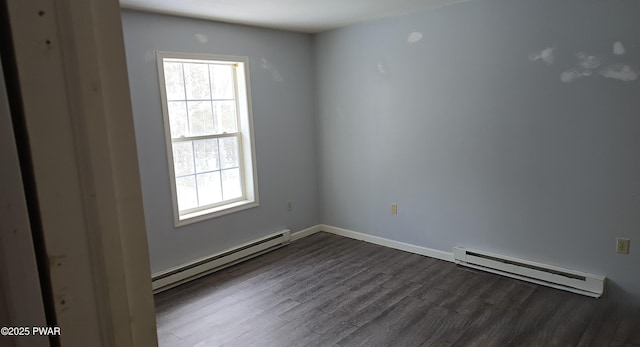 spare room with dark wood-style flooring, baseboards, and baseboard heating