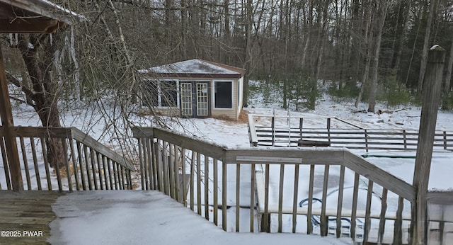 snow covered deck featuring an outbuilding