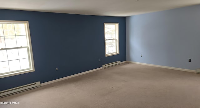 spare room featuring light carpet, baseboards, and a baseboard heating unit