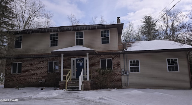 traditional-style house featuring brick siding and a chimney