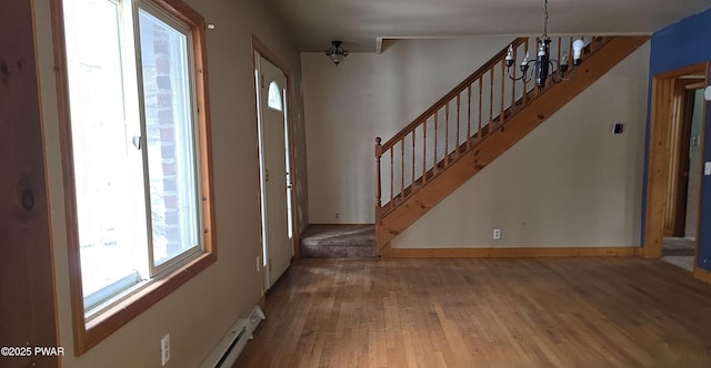 entrance foyer with stairs, baseboards, wood finished floors, and an inviting chandelier