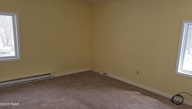 empty room with a baseboard heating unit, light carpet, visible vents, and baseboards