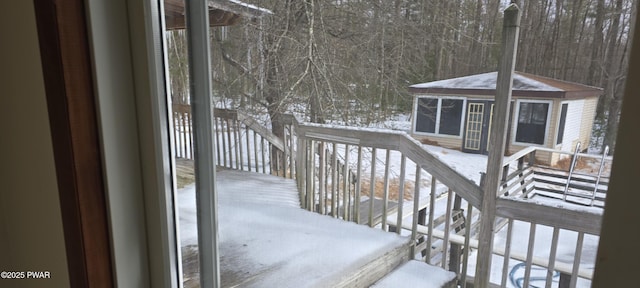 snow covered deck featuring an outbuilding