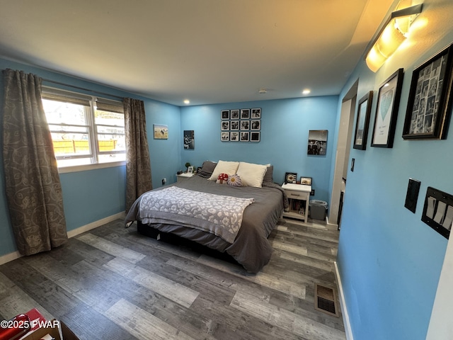 bedroom with recessed lighting, visible vents, baseboards, and wood finished floors