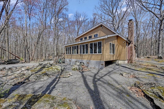 view of front of house with a chimney and a sunroom