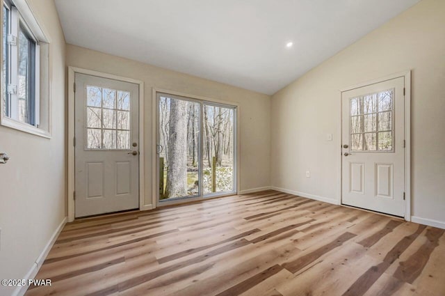 entryway featuring recessed lighting, baseboards, vaulted ceiling, and light wood-style floors