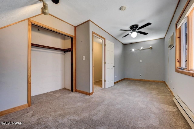 unfurnished bedroom with a baseboard radiator, ceiling fan, carpet, and a closet