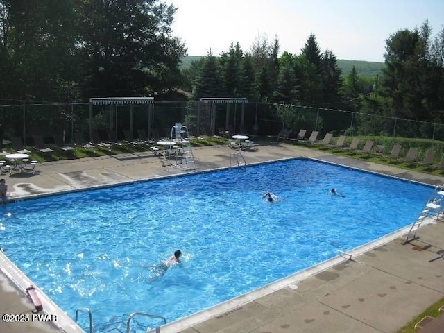 pool with a patio and fence
