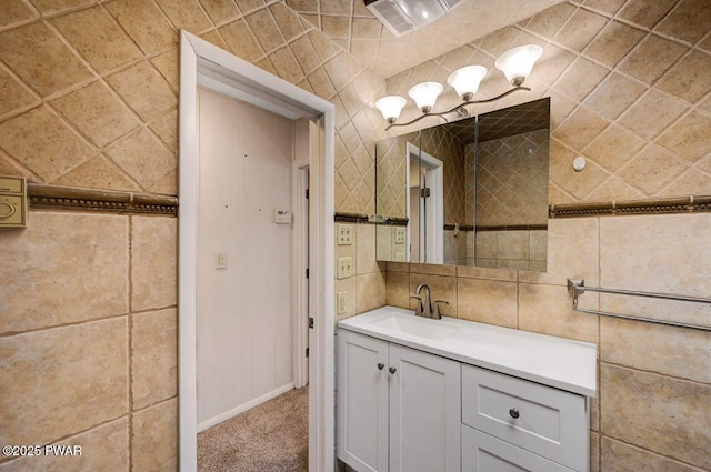 bathroom featuring baseboards, visible vents, tile walls, and vanity
