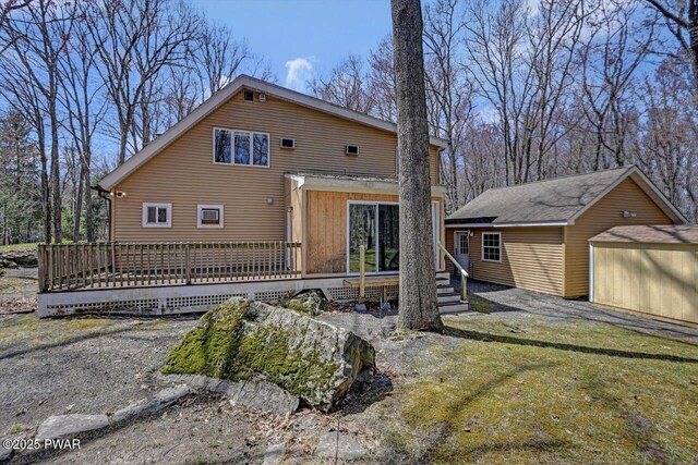 view of front of house with an outdoor structure, a deck, and a front yard