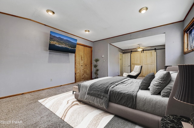 bedroom featuring crown molding, carpet flooring, a barn door, and baseboards