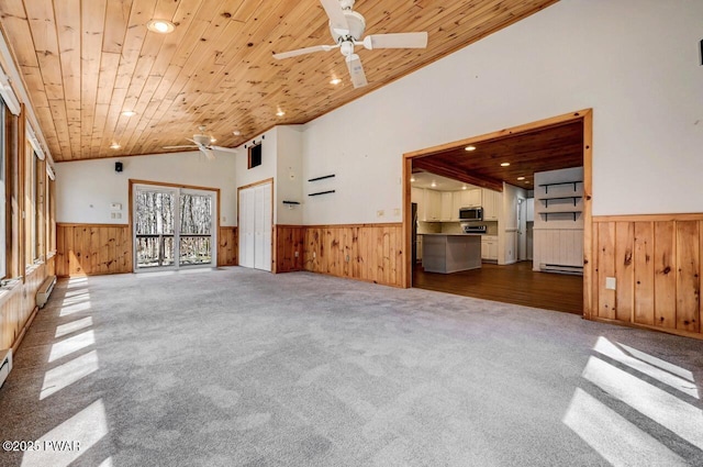 unfurnished living room with wainscoting, ceiling fan, and wooden walls