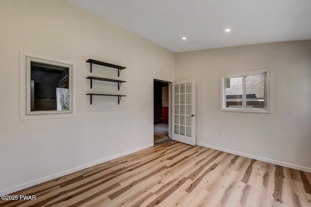 empty room with french doors, recessed lighting, light wood-style flooring, and baseboards