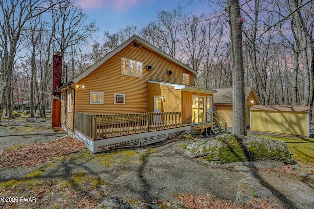 back of house with a chimney and a deck