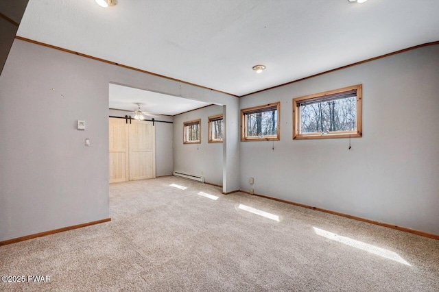 carpeted spare room with ornamental molding, a healthy amount of sunlight, baseboard heating, and baseboards