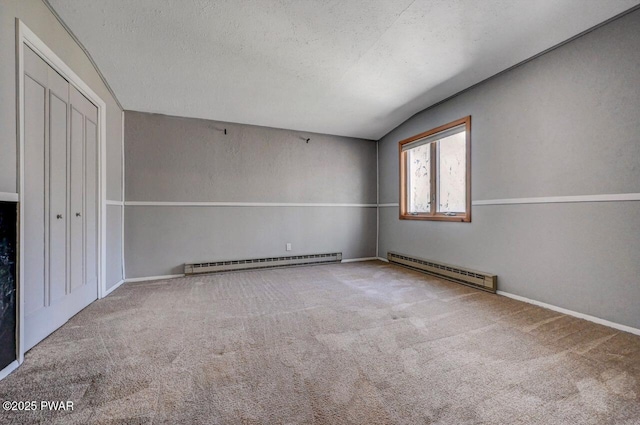 carpeted spare room with vaulted ceiling, a baseboard heating unit, baseboard heating, and baseboards