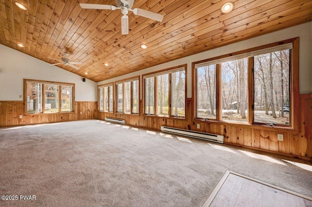 interior space featuring a ceiling fan, wood walls, baseboard heating, and wainscoting