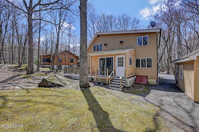 rear view of house with a lawn and a wooden deck