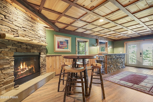 980 Long Ridge Rd, Hawley, PA 18428 - dining area featuring a stone fireplace, a wood ceiling with exposed beams, wood-type flooring, a wainscoted wall, and coffered ceiling