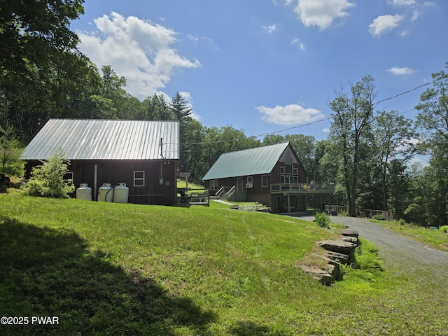 980 Long Ridge Rd, Hawley, PA 18428 - view of home's exterior featuring a metal roof, a lawn, driveway, and a wooden deck
