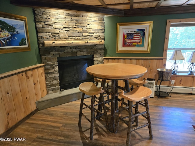 980 Long Ridge Rd, Hawley, PA 18428 - dining area featuring a wainscoted wall, wood finished floors, baseboard heating, a stone fireplace, and a wood ceiling with exposed beams