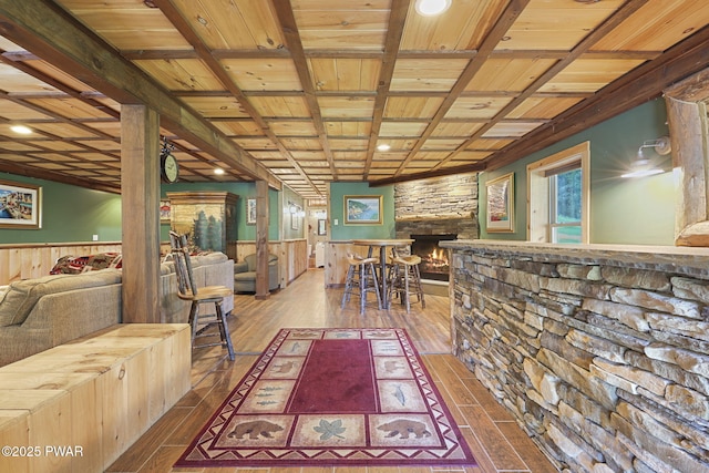 980 Long Ridge Rd, Hawley, PA 18428 - dining area featuring a wooden ceiling with exposed beams, wood-type flooring, wainscoting, wooden walls, and a stone fireplace