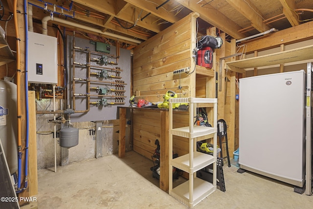 980 Long Ridge Rd, Hawley, PA 18428 - unfinished below grade area featuring freestanding refrigerator, tankless water heater, and a workshop area