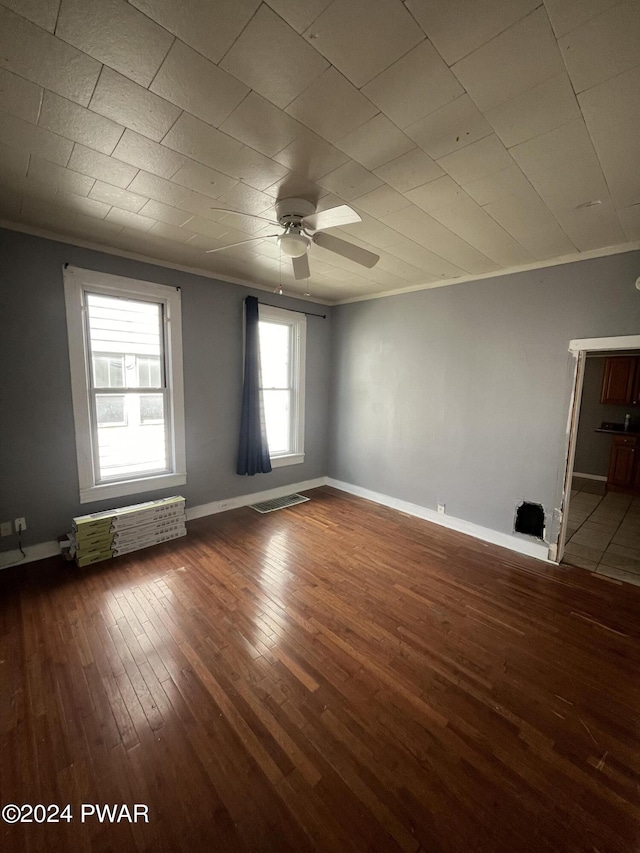 empty room with hardwood / wood-style floors, ceiling fan, and ornamental molding