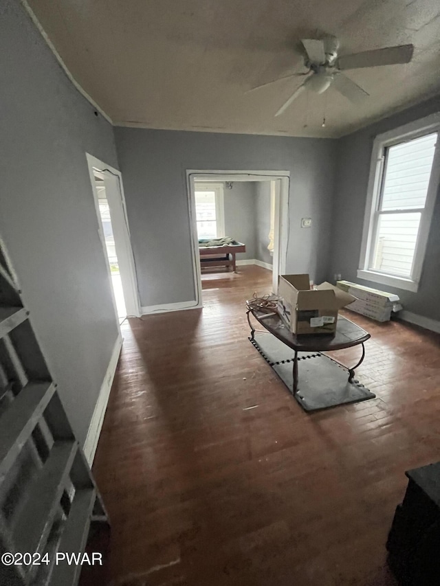 living room with dark hardwood / wood-style flooring and ceiling fan