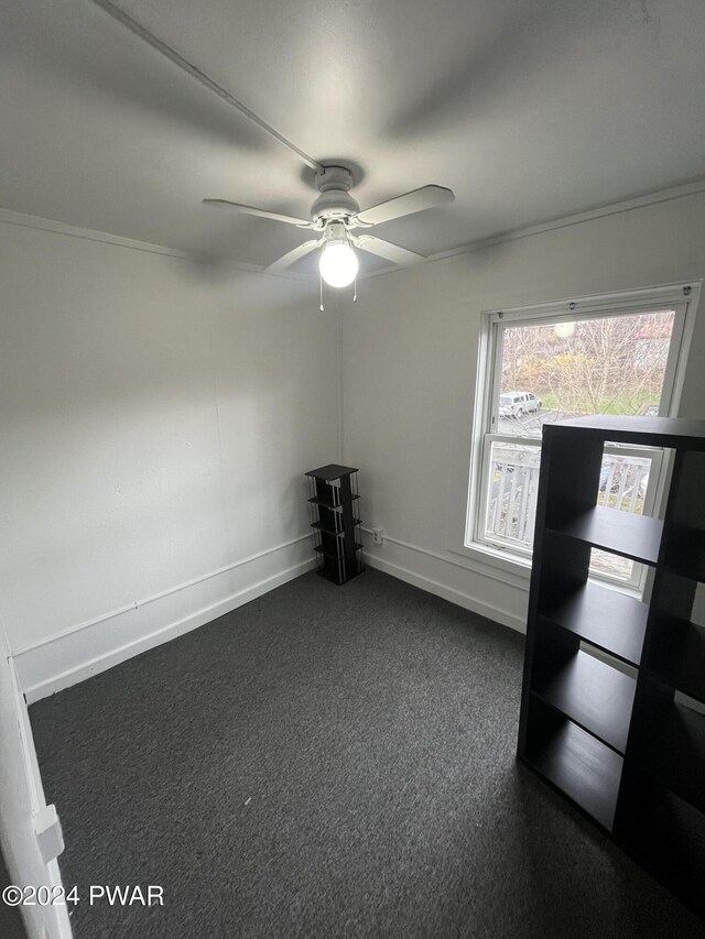 carpeted spare room featuring ceiling fan