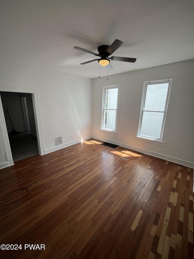 empty room with ceiling fan and dark wood-type flooring