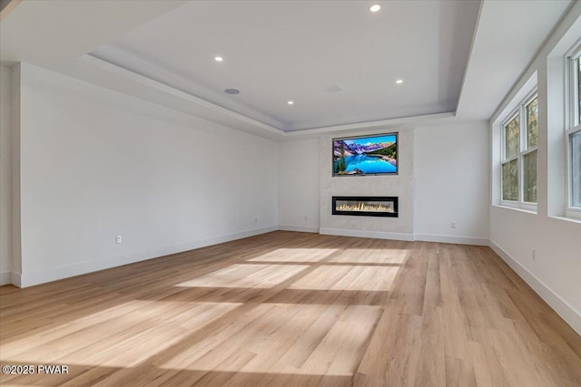 328 Forest Dr, Lords Valley, PA 18428 - unfurnished living room featuring a raised ceiling, a glass covered fireplace, light wood finished floors, and recessed lighting