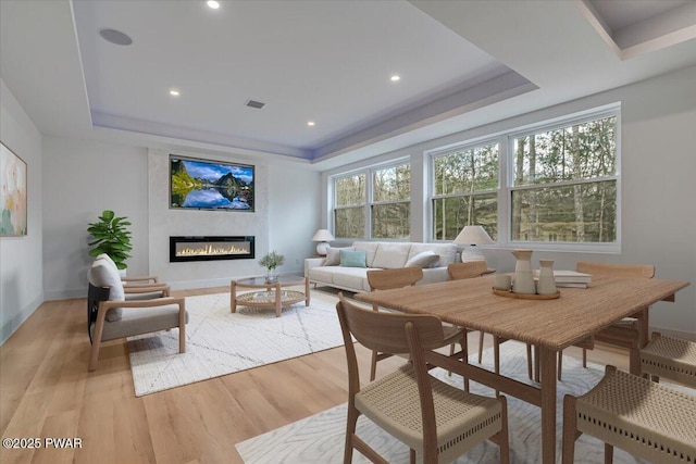 328 Forest Dr, Lords Valley, PA 18428 - living room featuring a raised ceiling, light wood-style floors, a glass covered fireplace, and recessed lighting