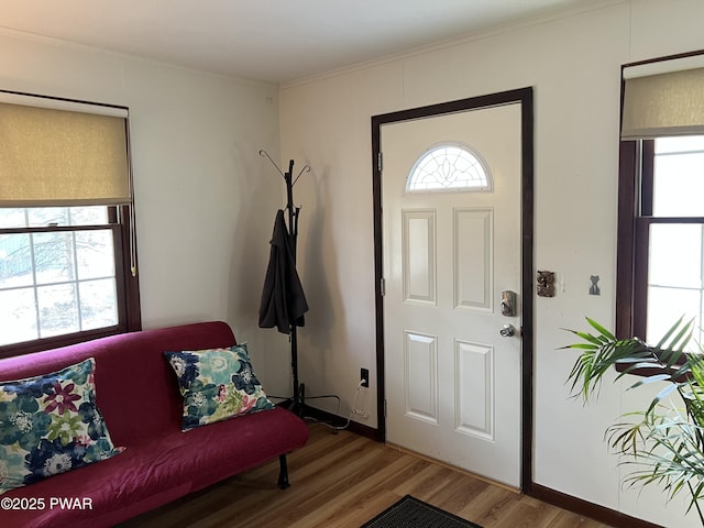 foyer entrance with baseboards, ornamental molding, and wood finished floors