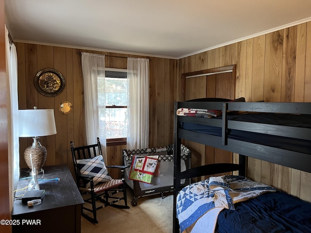 carpeted bedroom featuring wooden walls and ornamental molding