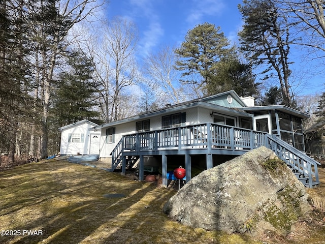 view of front of home with stairway and a sunroom