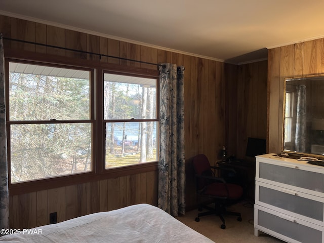 carpeted bedroom with wooden walls and ornamental molding