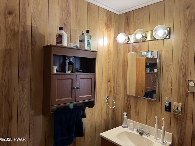 bathroom featuring a sink and wooden walls