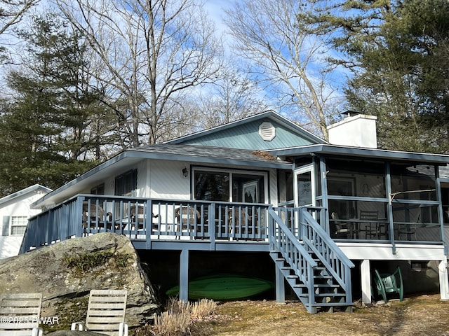 view of front of property with a chimney, a sunroom, and stairway