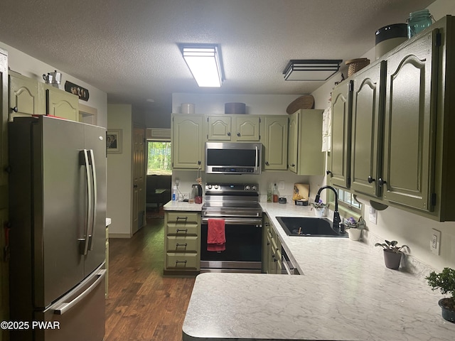 110 Stonefield Rd, Milford, PA 18337 - kitchen featuring appliances with stainless steel finishes, green cabinetry, light countertops, a peninsula, and a textured ceiling