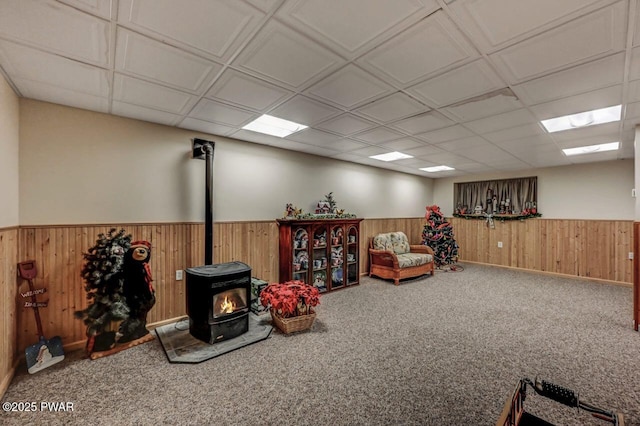 107 Musket Dr, Lackawaxen, PA 18435 - living area with a wood stove, wood walls, a wainscoted wall, and carpet flooring